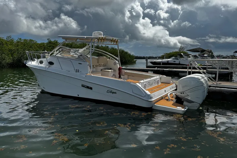 The Image of 2008 Seaswirl Striper 2901 Walkaround O/B boat docked, featuring twin outboard engines. - 0