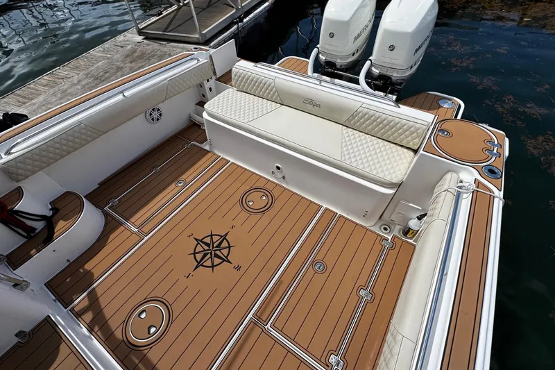 Slide: The Image of 2008 Seaswirl Striper 2901 Walkaround O/B boat deck with twin engines and cushioned seating. - 10