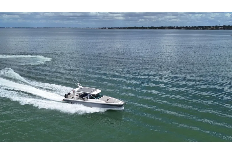 Slide: The Image of 2024 Axopar 37 Sun Top cruising on open water, rear view. - 12