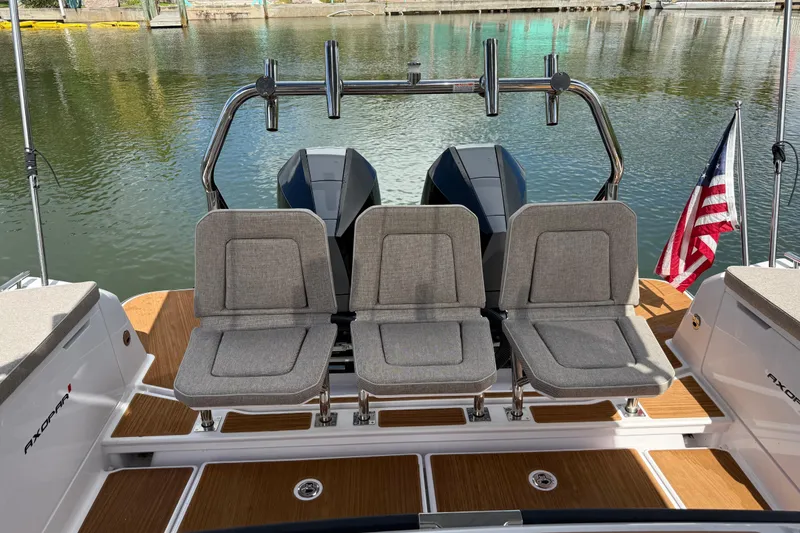 Slide: The Image of 2024 Axopar 37 Sun Top cruising on a sunny day with city skyline in background. - 14