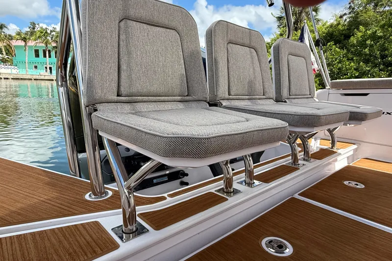 Slide: The Image of 2024 Axopar 37 Sun Top boat with triple seats and American flag on deck. - 15