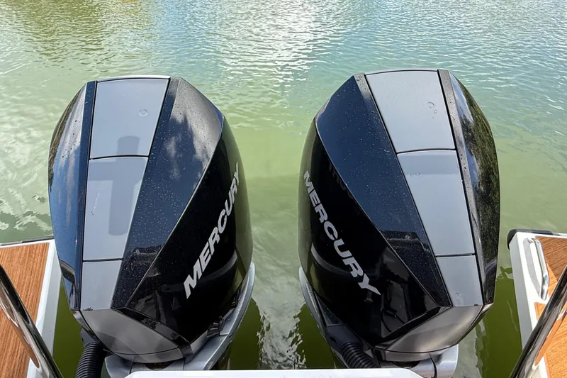 Slide: The Image of 2024 Axopar 37 Sun Top boat interior with seating and American flag by the water. - 18