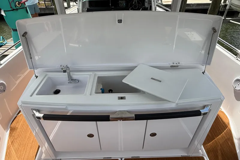 Slide: The Image of 2024 Axopar 37 Sun Top boat cruising in a scenic canal with palm trees. - 21