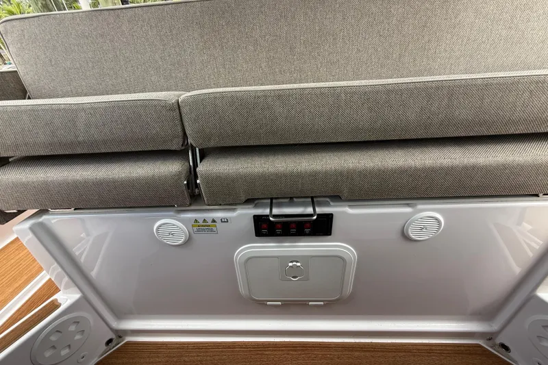 Slide: The Image of 2024 Axopar 37 Sun Top interior with beige seating and wooden flooring. - 25