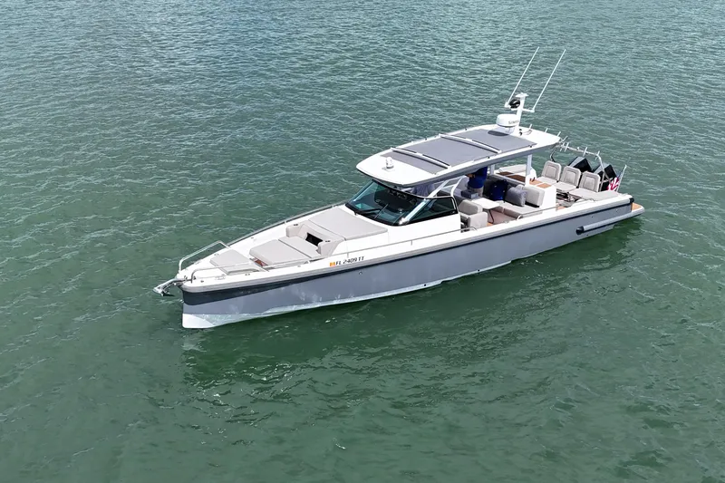 Slide: The Image of 2024 Axopar 37 Sun Top boat on calm green water, aerial view. - 3