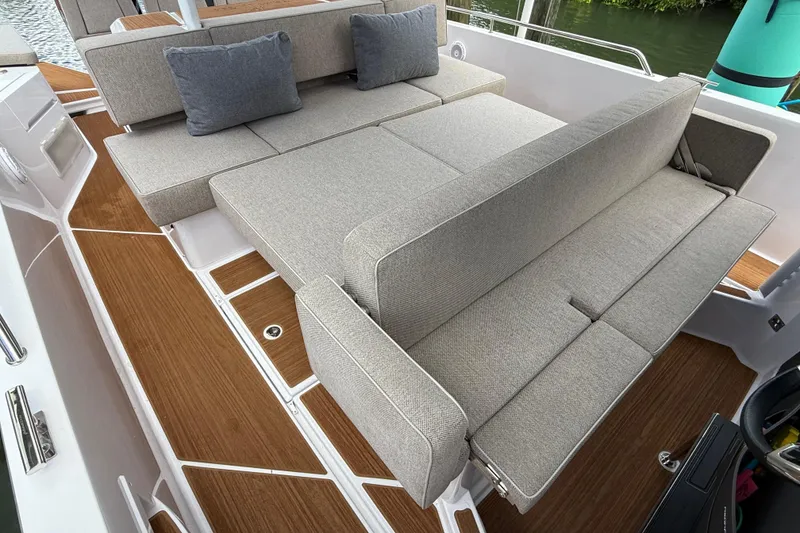Slide: The Image of 2024 Axopar 37 Sun Top boat interior with cushioned seating and wooden flooring. - 30