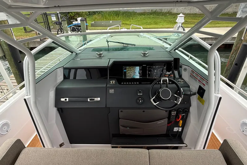 Slide: The Image of 2024 Axopar 37 Sun Top storage compartment with open hatch and wood finish. - 37