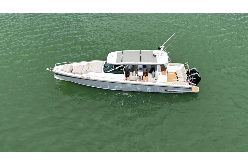 Slide: The Image of 2024 Axopar 37 Sun Top boat cruising on a calm, scenic waterway. - 4