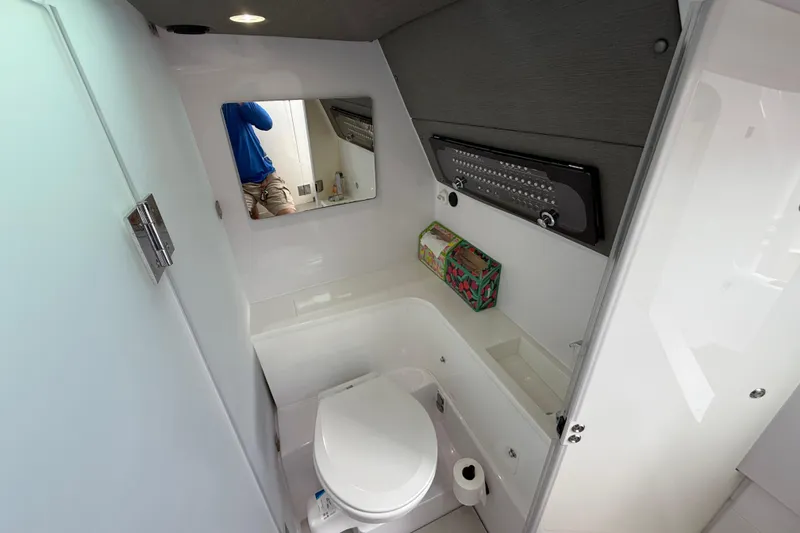 Slide: The Image of 2024 Axopar 37 Sun Top bathroom interior with modern fixtures and mirror. - 44