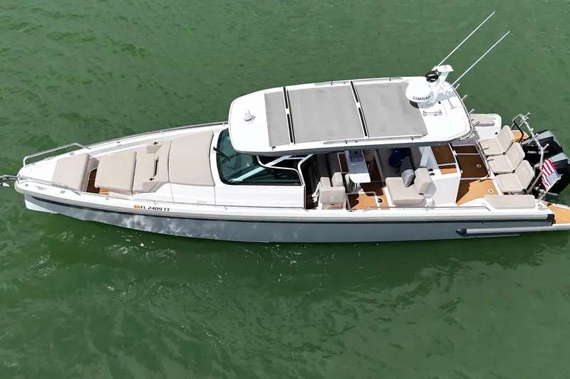 Slide: The Image of 2024 Axopar 37 Sun Top boat on clear water, aerial view. - 5