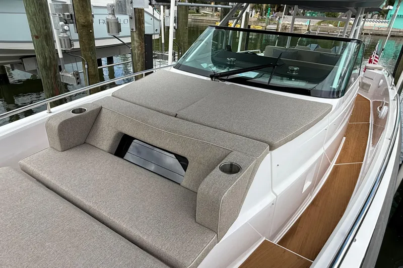 Slide: The Image of 2024 Axopar 37 Sun Top boat with cushioned seating and sleek design. - 52