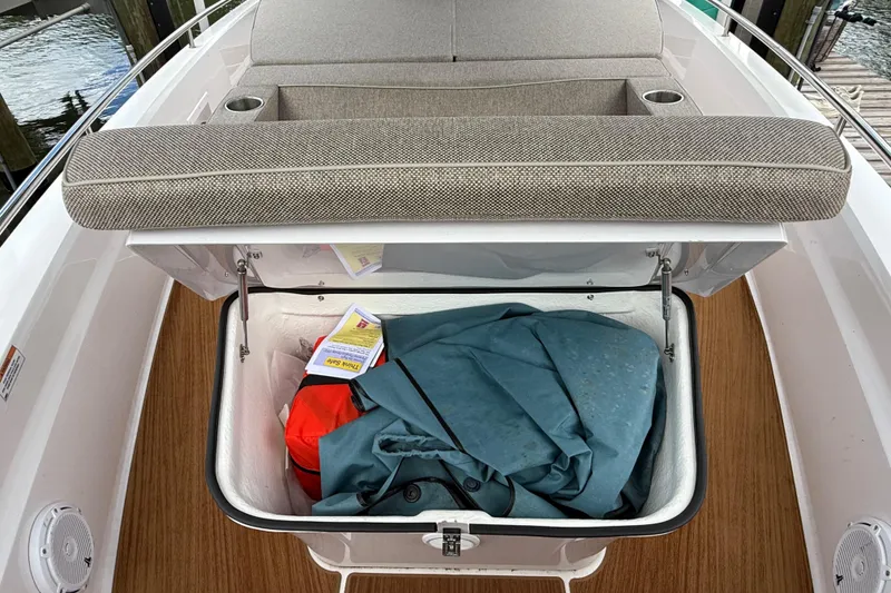 Slide: The Image of 2024 Axopar 37 Sun Top storage compartment with cushions and gear on deck. - 55