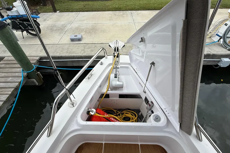 Slide: The Image of 2024 Axopar 37 Sun Top boat anchor storage compartment with safety equipment. - 56