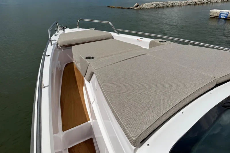 Slide: The Image of 2024 Axopar 37 Sun Top boat with spacious sunbathing area on calm water. - 57