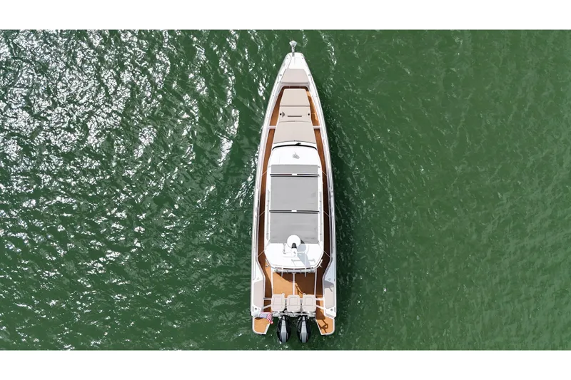 Slide: The Image of 2024 Axopar 37 Sun Top boat on water, rear view with dual engines. - 9