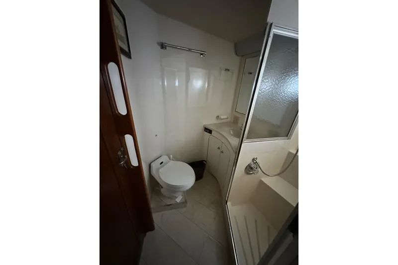 Slide: The Image of Laundry area inside 1988 Hatteras 48 Convertible yacht, featuring a compact washer-dryer unit. - 22