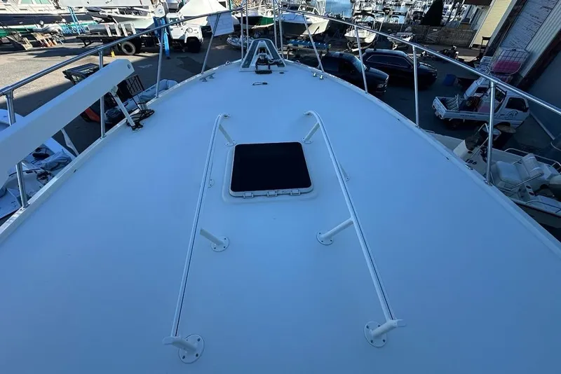 Slide: The Image of Engine compartment of 1988 Hatteras 48 Convertible boat, featuring machinery and warning label. - 44