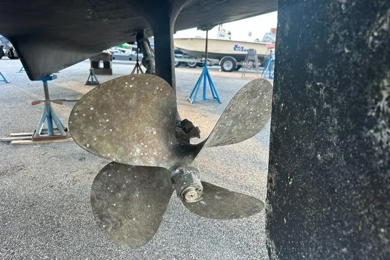 Slide: The Image of Propeller of 1988 Hatteras 48 Convertible boat on dry dock with stands. - 54