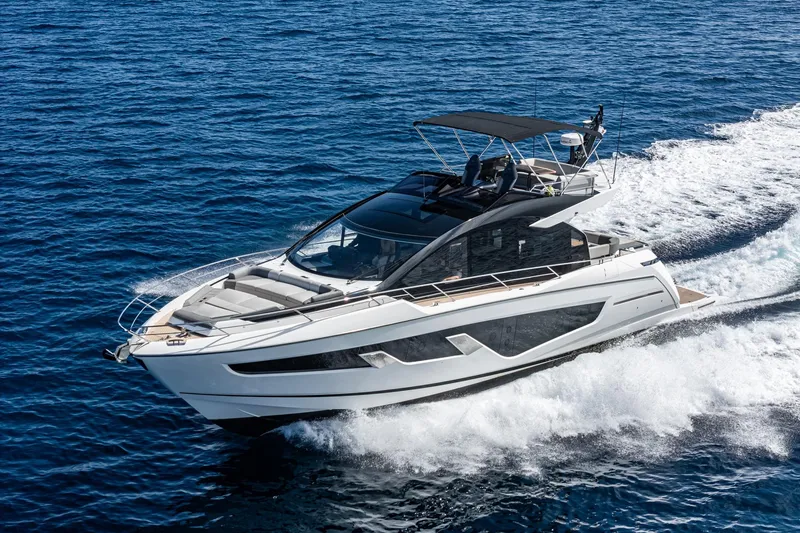 Slide: The Image of 2023 Sunseeker 65 Sport Yacht cruising on open water, showcasing sleek design and luxury. - 2