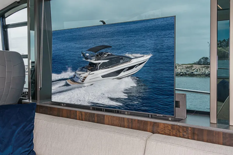 Slide: The Image of 2023 Sunseeker 65 Sport Yacht displayed on a modern TV screen indoors. - 32