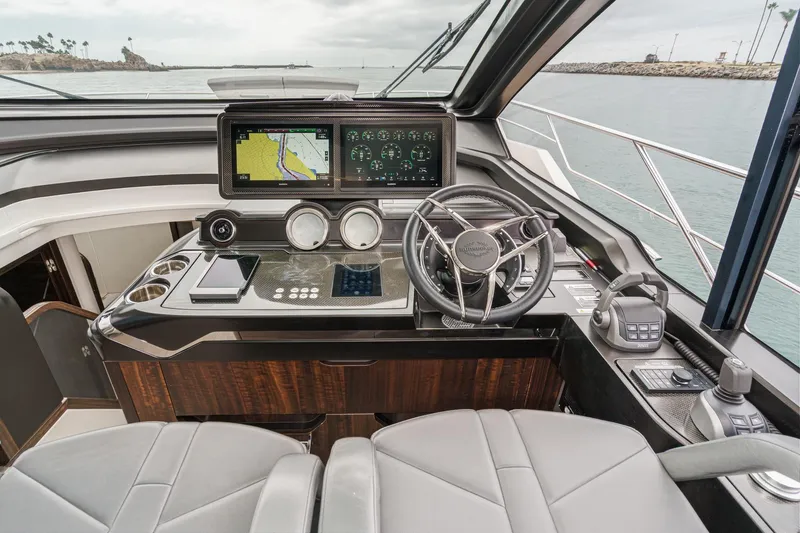 Slide: The Image of 2023 Sunseeker 65 Sport Yacht helm with advanced navigation displays and luxurious seating. - 33
