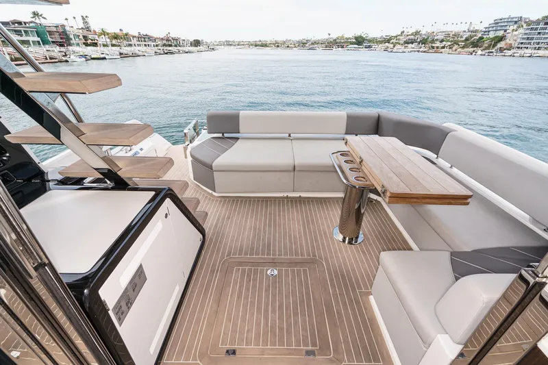 Slide: The Image of Luxurious 2023 Sunseeker 65 Sport Yacht deck with elegant seating and wooden table. - 8