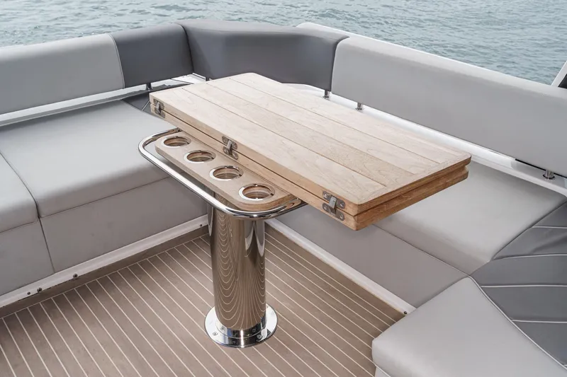 Slide: The Image of Luxury seating area on 2023 Sunseeker 65 Sport Yacht with wooden table and cup holders. - 9