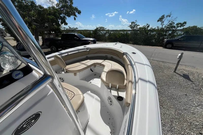 Slide: The Image of 2014 Sportsman Heritage 211 Center Console boat with beige seating, parked near trees. - 12