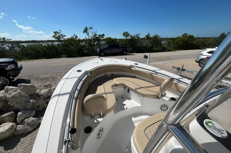 Slide: The Image of 2014 Sportsman Heritage 211 Center Console boat with beige seating, parked near a scenic road. - 14