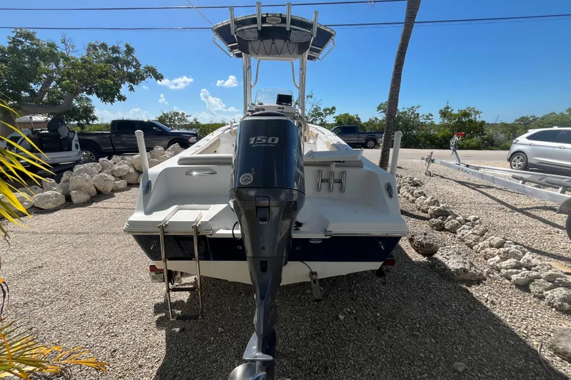 Slide: The Image of 2014 Sportsman Heritage 211 Center Console boat with 150 HP engine, parked outdoors. - 6