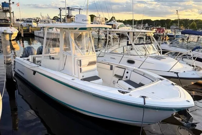 The Image of 2019 Blackfin 242 CC boat docked, featuring sleek design and turquoise accents under a clear sky. - 0
