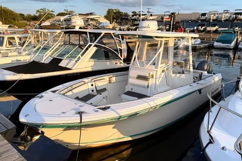 Slide: The Image of 2019 Blackfin 242 CC boat docked in a marina, featuring sleek design and modern amenities. - 1
