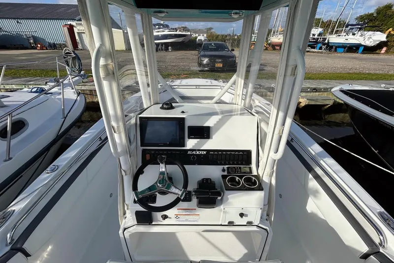 Slide: The Image of 2019 Blackfin 242 CC boat dashboard with steering wheel and navigation controls. - 10