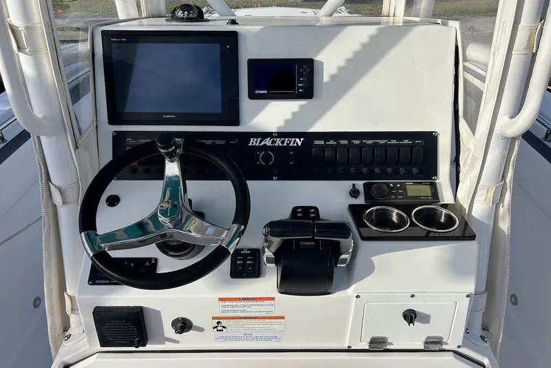 Slide: The Image of 2019 Blackfin 242 CC boat dashboard with steering wheel, controls, and electronic displays. - 11