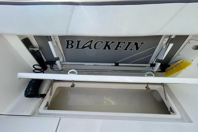Slide: The Image of 2019 Blackfin 242 CC boat storage compartment with cleaning tools and accessories. - 17