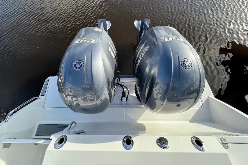 Slide: The Image of Twin Yamaha outboard engines on a 2019 Blackfin 242 CC boat, docked on calm water. - 20