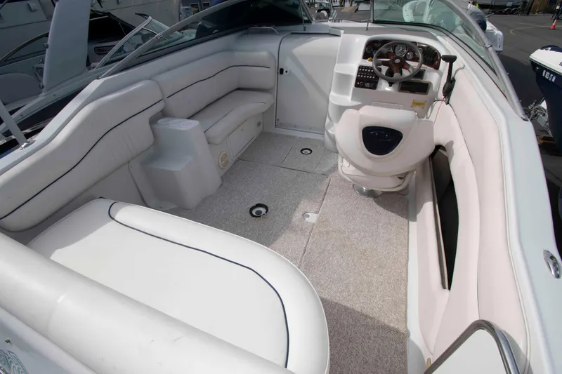 Slide: The Image of 2004 Crownline 235 CCR boat interior with white seating and steering console. - 2