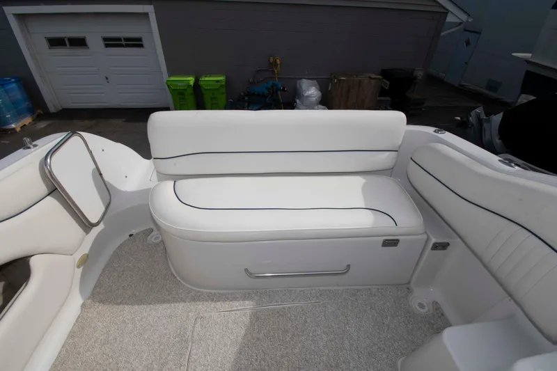 Slide: The Image of 2004 Crownline 235 CCR boat interior with white cushioned seating and storage compartment. - 5