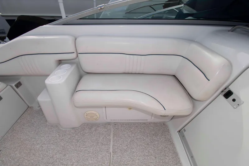 Slide: The Image of 2004 Crownline 235 CCR boat interior with white cushioned seating and cup holders. - 6