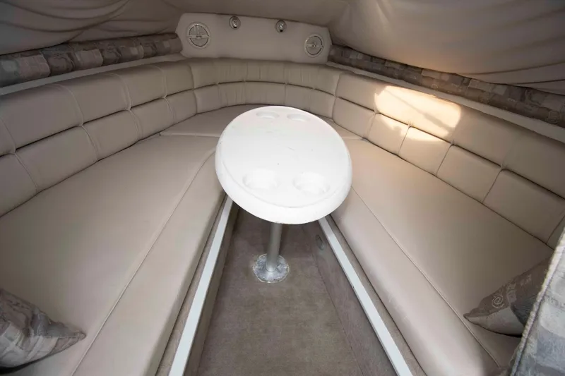Slide: The Image of 2004 Crownline 235 CCR cabin interior with beige seating and a round table. - 7