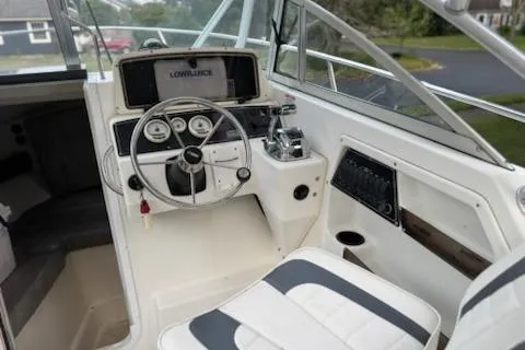 Slide: The Image of 2000 Boston Whaler 23 Conquest boat cockpit with steering wheel and navigation equipment. - 10