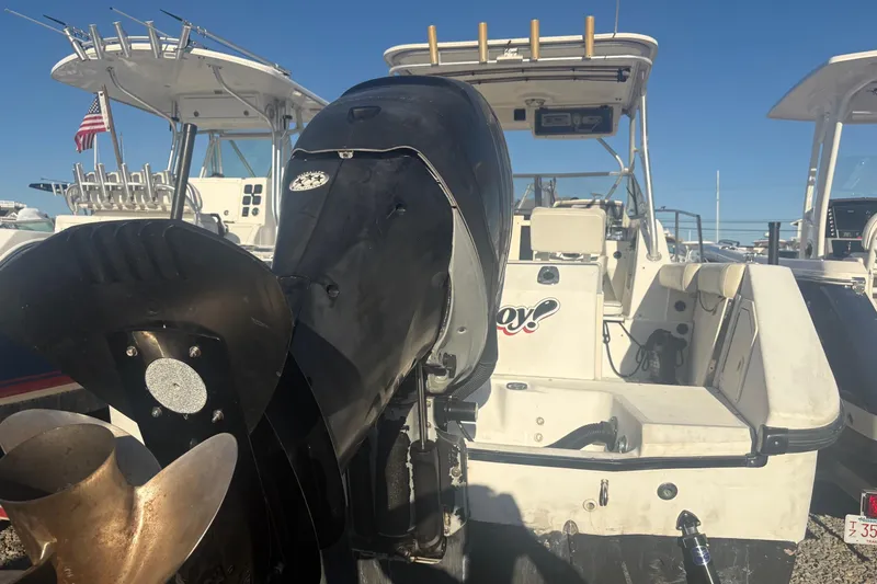 Slide: The Image of 2000 Boston Whaler 23 Conquest boat with outboard motor, docked under clear blue sky. - 8