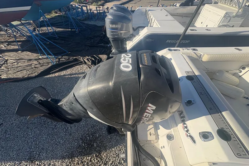 Slide: The Image of Boston Whaler 23 Conquest 2000 with Mercury 250 outboard engine, docked on gravel. - 9