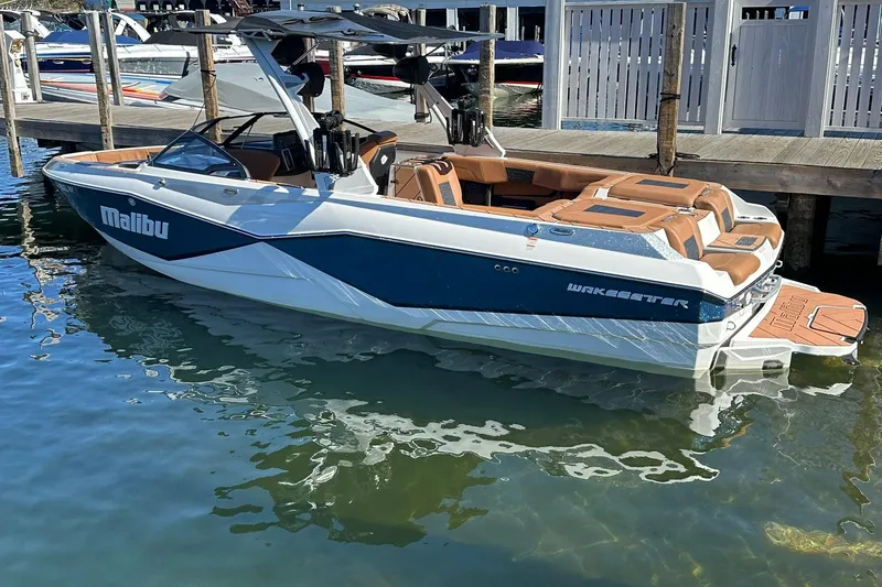 Slide: The Image of 2024 Malibu Wakesetter 25 LSV boat docked, featuring sleek design and luxurious seating. - 3