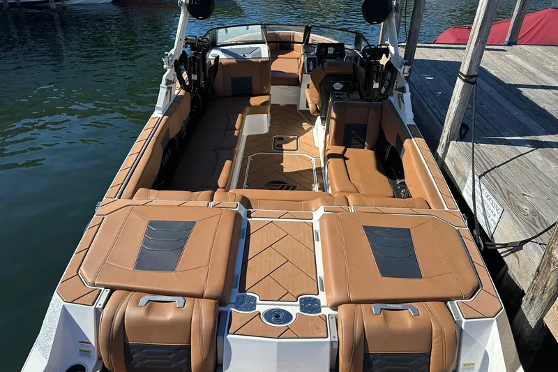 Slide: The Image of 2024 Malibu Wakesetter 25 LSV boat interior with luxurious brown seating and sleek design. - 9