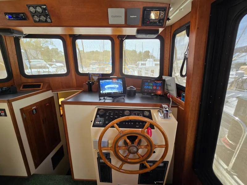 Slide: The Image of Interior of 2001 Nordic Tug 32 with cozy seating and striped cushions. - 8