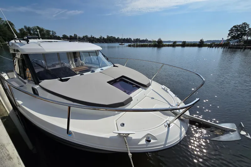 Slide: The Image of 2023 Jeanneau NC Sport 795 Series 2 boat docked on a serene lake. - 2