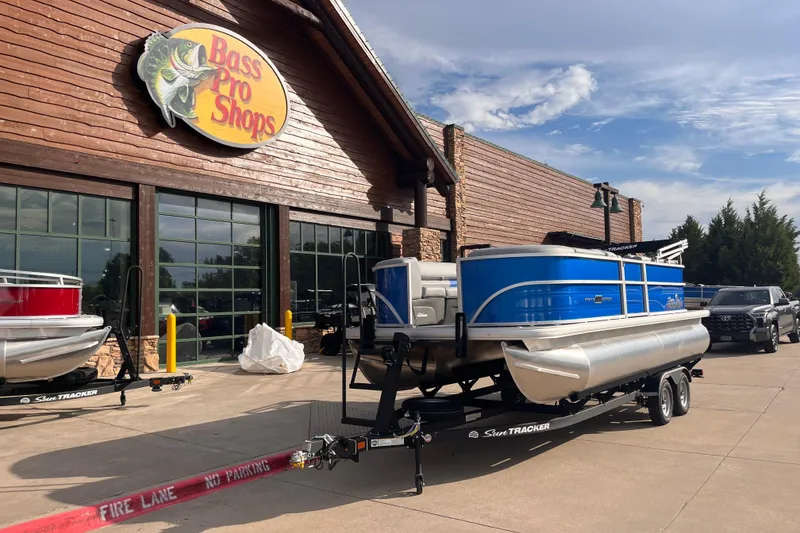 Slide: The Image of 2026 Sun Tracker Party Barge 20 DLX pontoon boat at Bass Pro Shops entrance. - 70