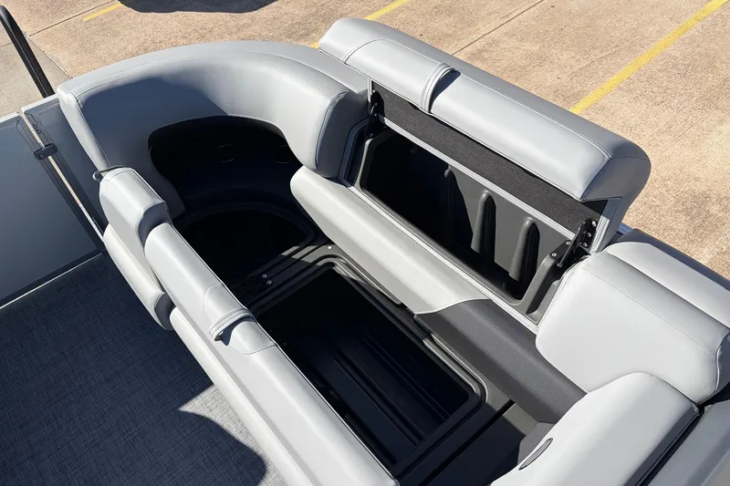 Slide: The Image of 2026 Sun Tracker Party Barge 22 RF XP3 with open storage compartment and gray seating. - 26