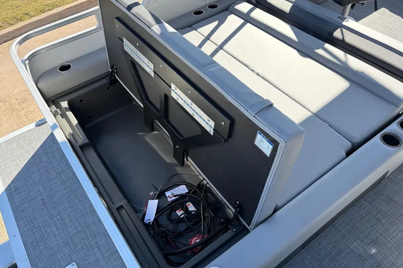 Slide: The Image of 2026 Sun Tracker Party Barge 22 RF XP3 storage compartment with open seat and wiring. - 48